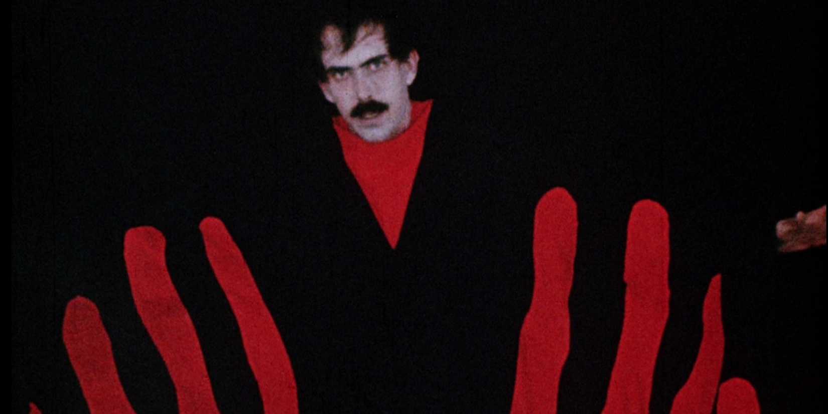 A man in a black background in Manos_ The Hands of Fate