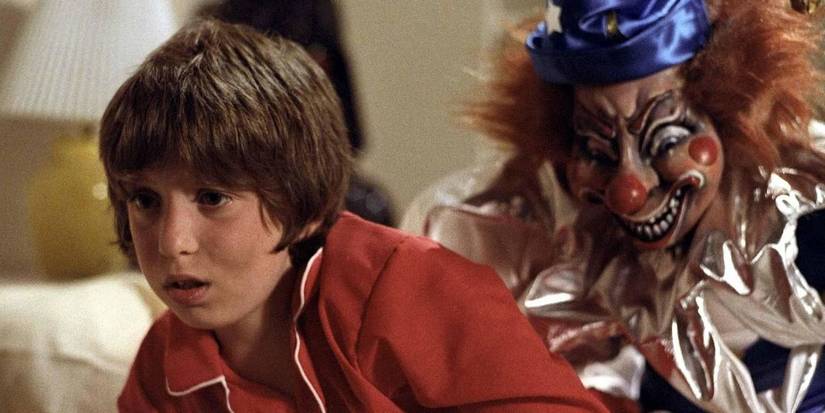 Robbie looking scared while a clown stalks him from behind in Poltergeist