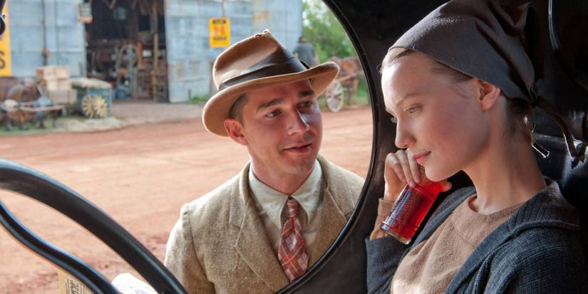 Mia Wasikowska sitting inside a car while Shia LaBeouf stands outside in Lawless