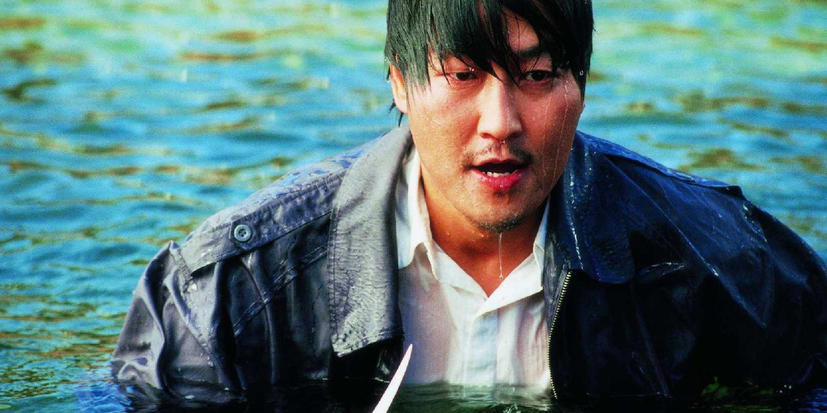 Park Dong-ji, played by actor Song Kang-ho, emerging from a lake in Sympathy For Mr. Vengeance