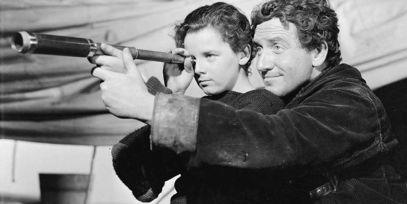 Spencer Tracy holding the binoculars of a child in Captains Courageous.
