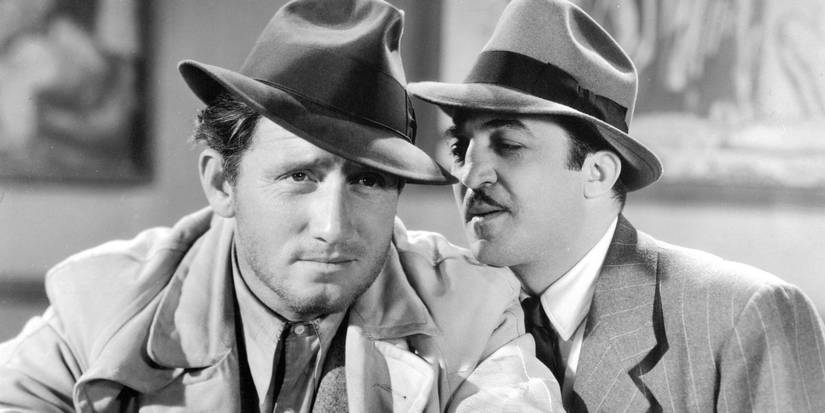 A man whospering in Spencer Tracy's ear in Fury