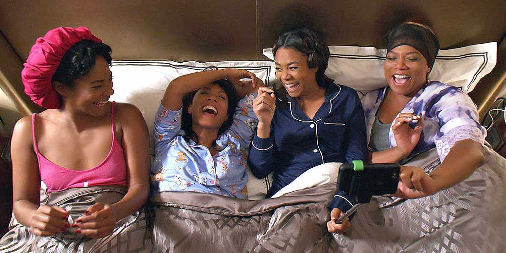 The cast of Girls Trip in bed laughing