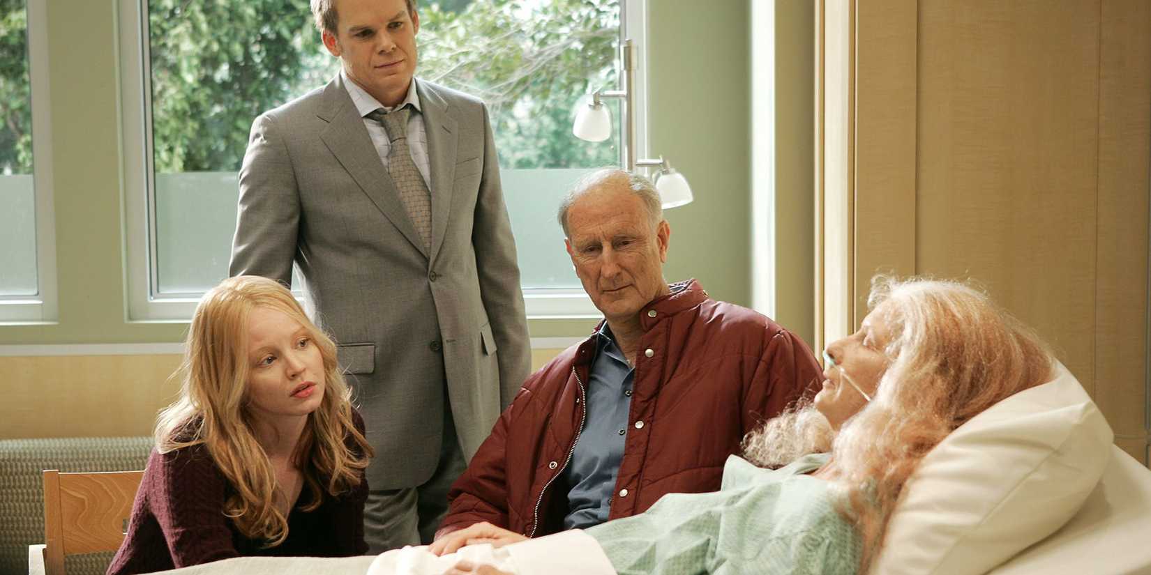 Uma Claire e David mais velhos ficam sobre a cama do hospital de Ruth em um metro e oitenta.