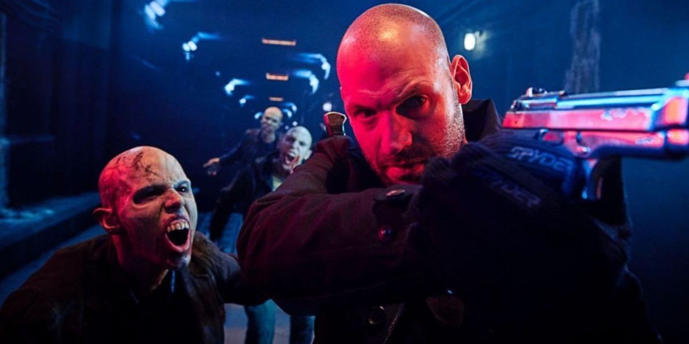 Corey Stoll points a gun with creatures begind him in The Strain.