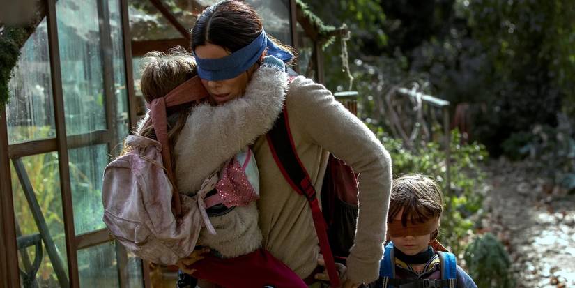 Sandra Bullock holding two children in Bird Box Netflix Movie