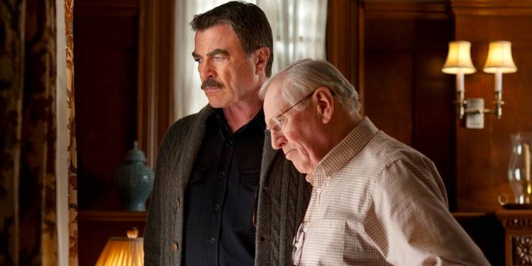 Frank (Tom Selleck) and Henry Reagan (Len Cariou) stand together in their family home looking out the window