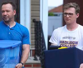 Danny Reagan (Donnie Wahlberg) and his son, Jack Reagan (Tony Terraciano), carry bins outside in Blue Bloods