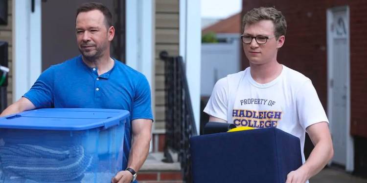 Danny Reagan (Donnie Wahlberg) and his son, Jack Reagan (Tony Terraciano), carry bins outside in Blue Bloods