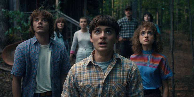 The cast stand in the woods and look up to the sky in Stranger Things episode The Piggyback.