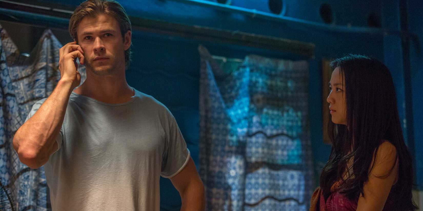 Chris Hemsworth as Nicholas and Tang Wei as Chen Lien standing together in a room in Blackhat