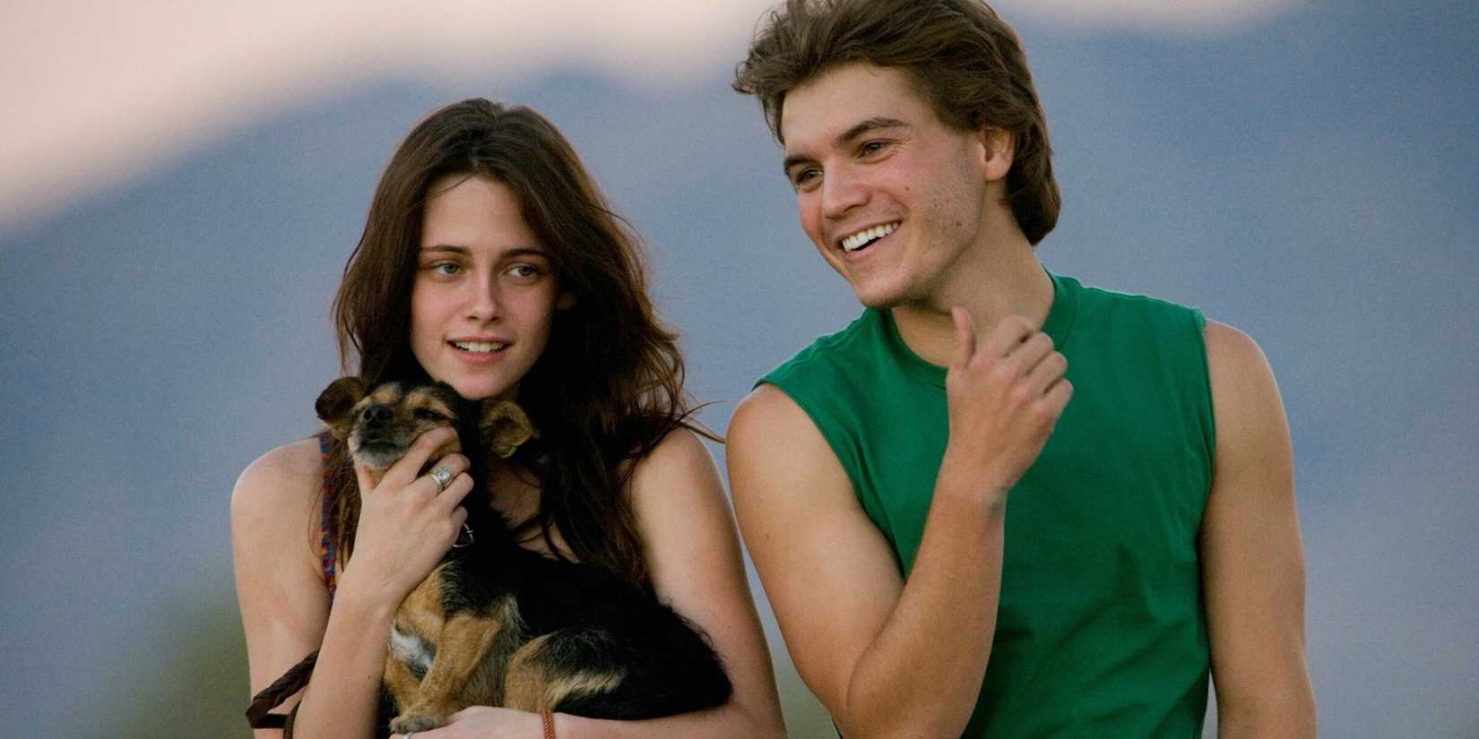 Emile Hirsch and Kristen Stewart in Into the Wild smiling. She holds a puppy in her arms.