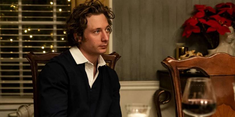Carmen (Jeremy Allen White) in a sweater in the dining room decorated for Christmas in The Bear.