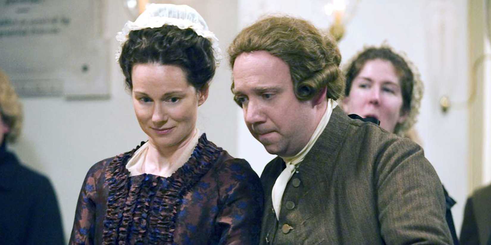 Paul Giamatti and Laura Linney observing ongoing events with interest as John and Abigail Adams in John Adams.