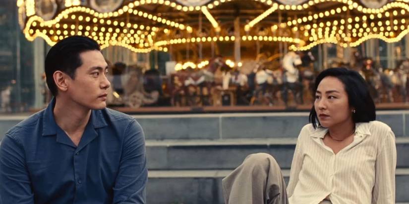 Hae Sung and Nora looking at each other while sitting in some steps in 'Past Lives' (2023)