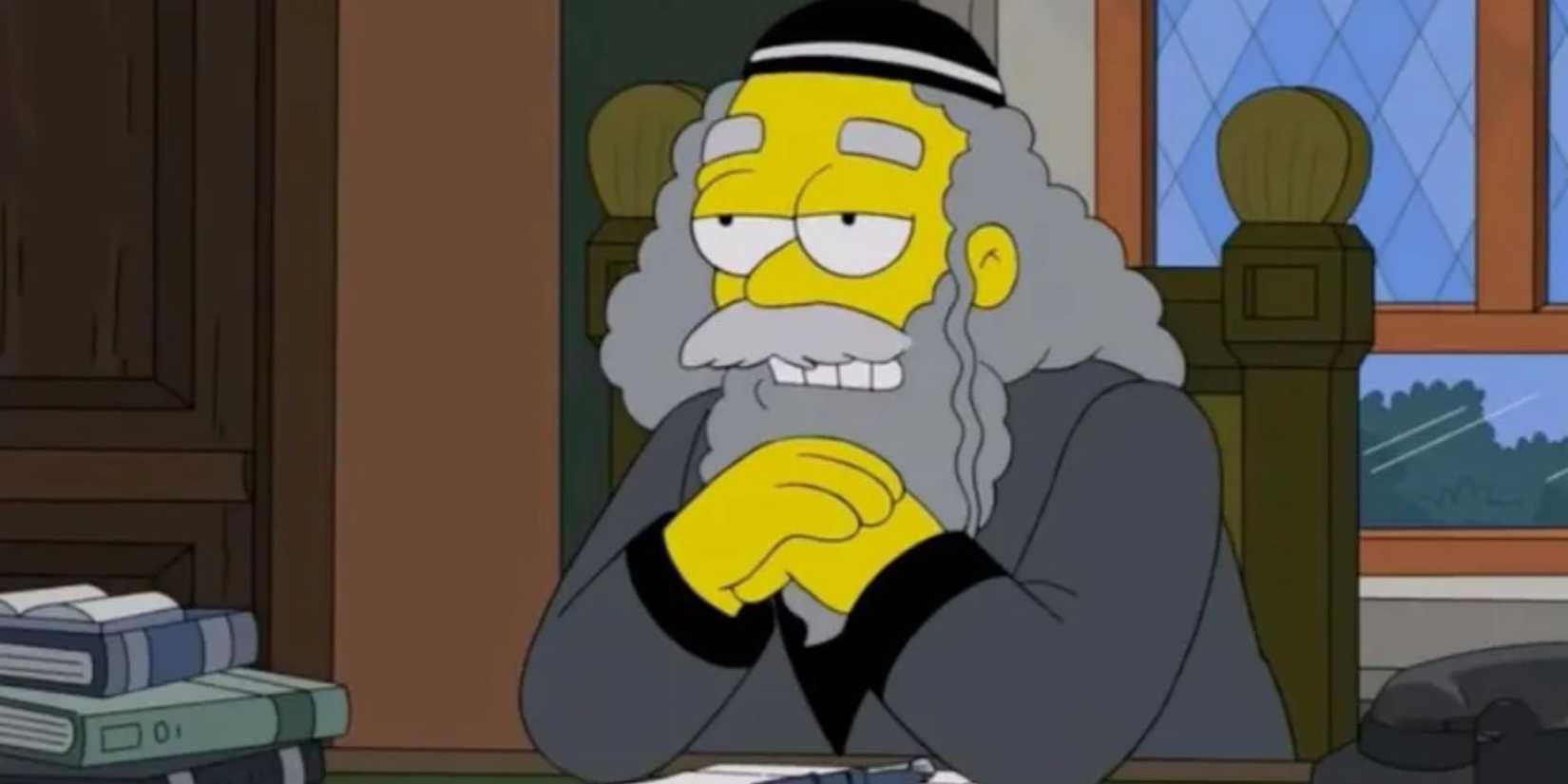 Rabbi Krustofsky sits at his desk with hands folded and looking ahead in The Simpsons.