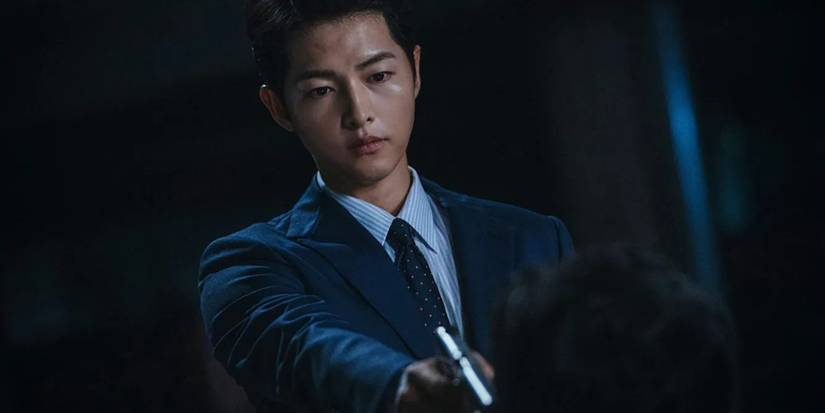 A man pointing a gun looking down in the Korean Drama "Vincenzo."