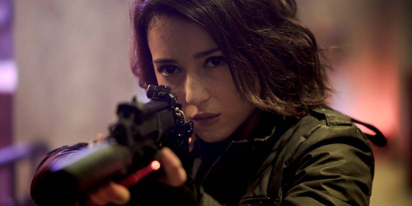 Julie Estelle looking down the scope of a weapon in The Night Comes for Us.