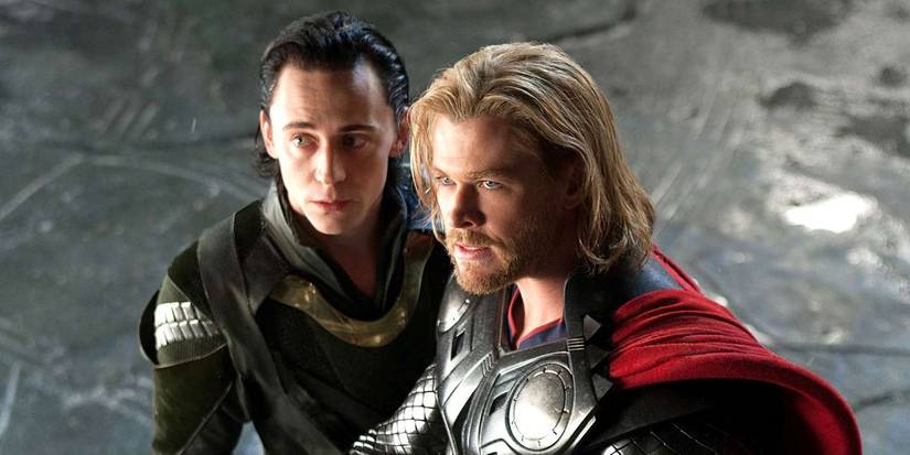 Chris Hemsworth as Thor and Tom Hiddleston as Loki standing together while looking at something off-screen, just in the upper left corner of the image.