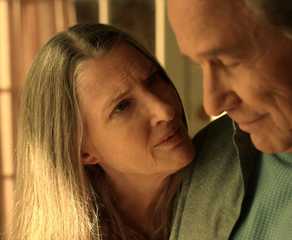 A woman looks concerned as she talks to a man who is grinning slightly in Virgin River.
