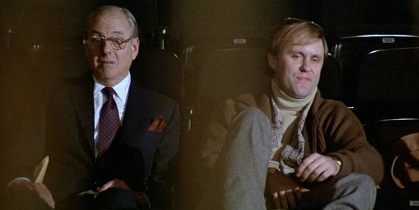 John Lithgow as Lucas Sargeant sitting next to another man in the film All That Jazz