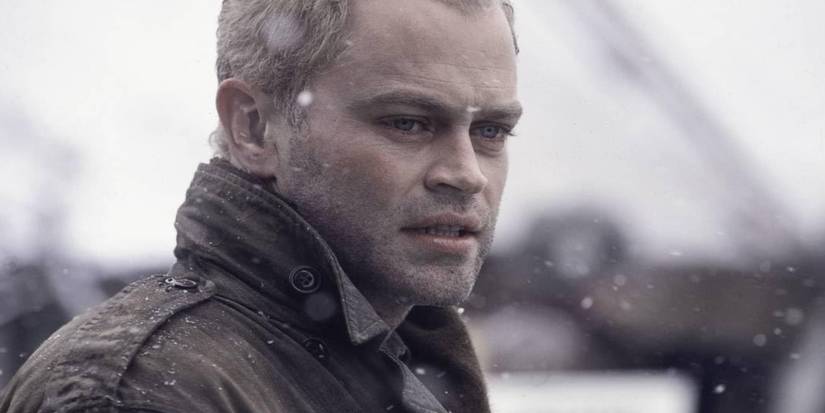 Neal McDonough looks concerned at something off-camera as snow falls in Band of Brothers.