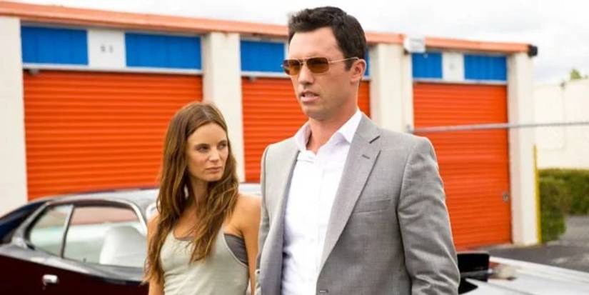 Michael Westen and Fiona walk near storage units in Burn Notice. 