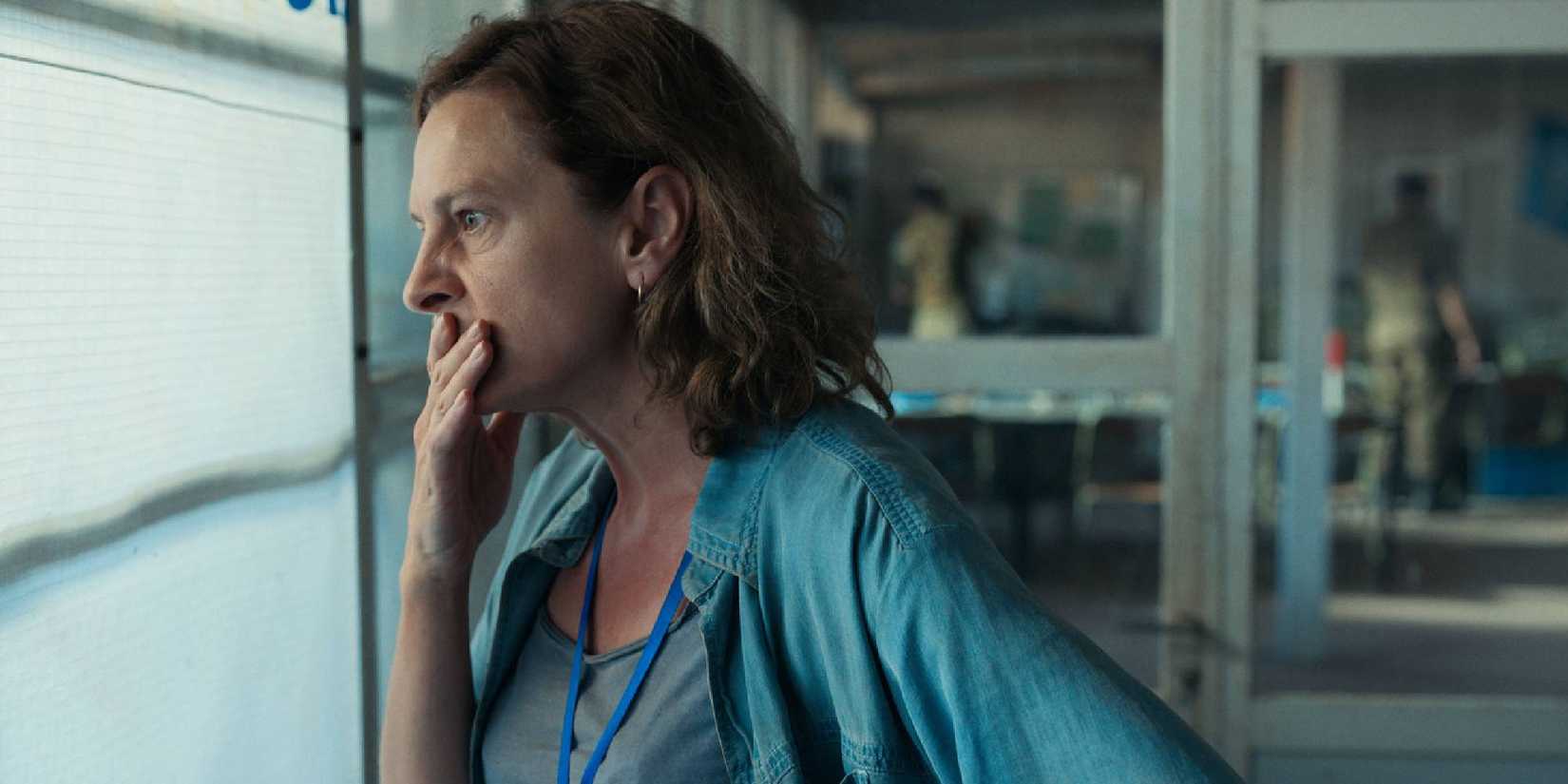 Aida with a worried expression while looking into a window in Quo Vadis, Aida?