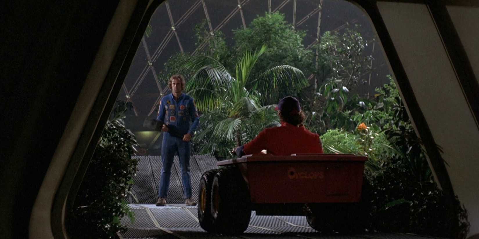 A man in a car approaches Bruce Dern as Freeman Lowell inside a greenhouse in Silent Running