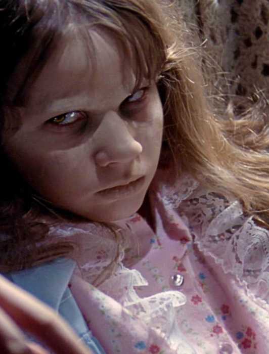 Linda Blair as a possessed Regan seated in 'The Exorcist'.