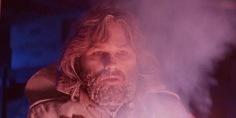 Kurt Russell as R.J. MacReady covered in snow and looking intently off-camera in The Thing