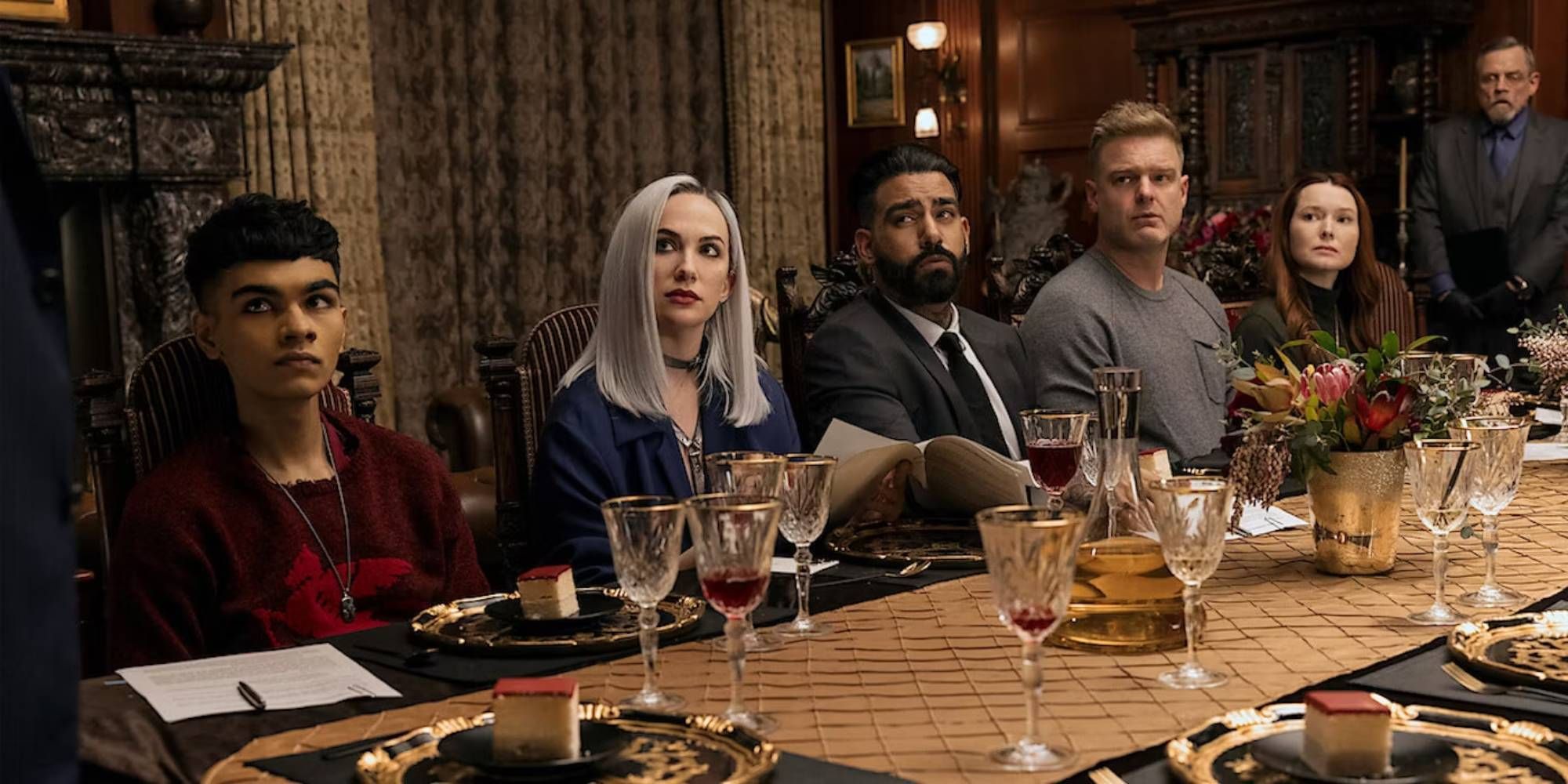 From left to right: Sauriyan Sapkota as Prospero Usher, Kate Siegel as Camille, Rahul Kohli as Napoleon Usher, Matt Biedel as William, and Samantha Sloyan as Tamerlane in The Fall of the House of Usher sitting at the table.