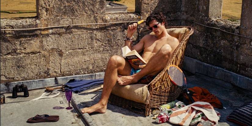 Felix Catton (Jacob Elordi) reads Harry Potter and the Deathly Hallows while eating a popsicle in Saltburn