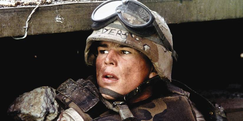 Josh Hartnett as Eversmann hiding and looking to the distance in Black Hawk Down (2001).