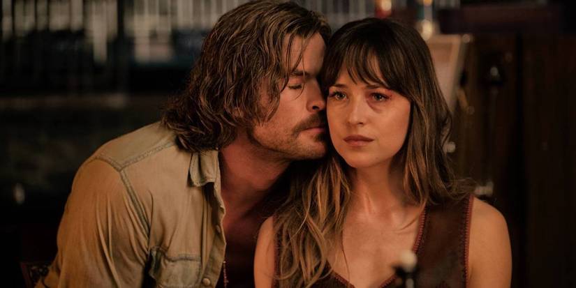 Chris Hemsworth as Billy Lee presing his face against Dakota Johnson as Emily Summerspring's cheek in Bad Times at the El Royale