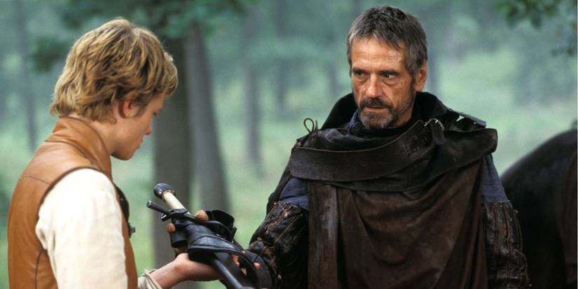 Jeremy Irons as Brom handing Ed Speleers as Eragon a sword in Eragon 2006 film.