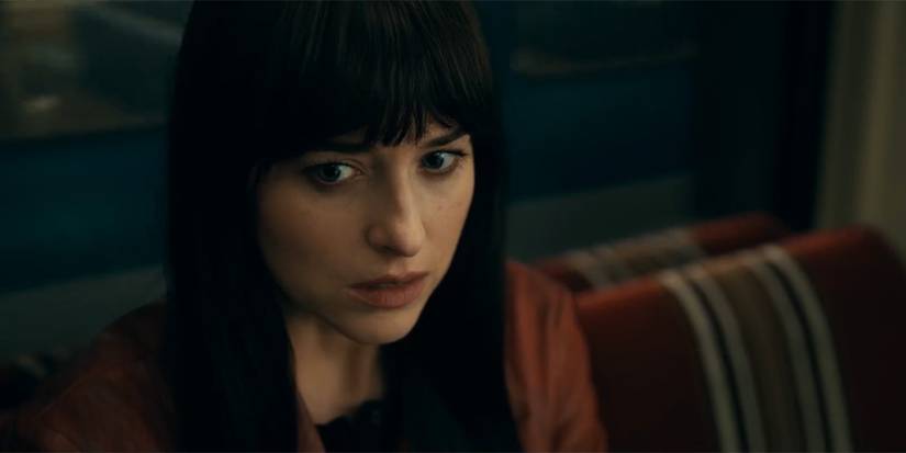Dakote Johnson as Cassie Webb looking frightened on a subway train in Madame Web