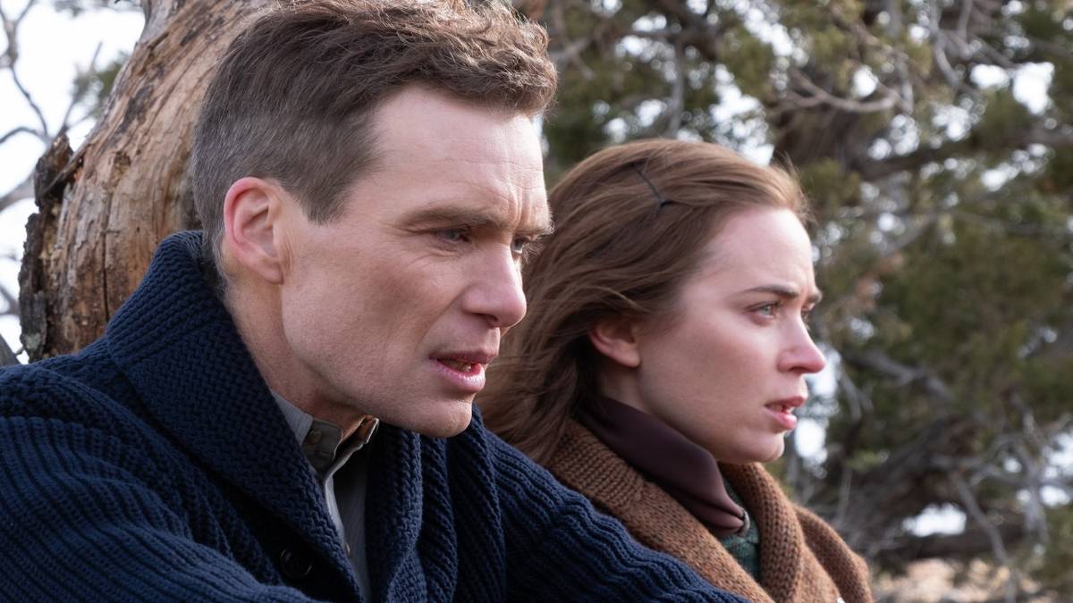 Oppenheimer (Cillian Murphy) and Kitty (Emily Blunt) sitting outside in the cold in Oppenheimer 