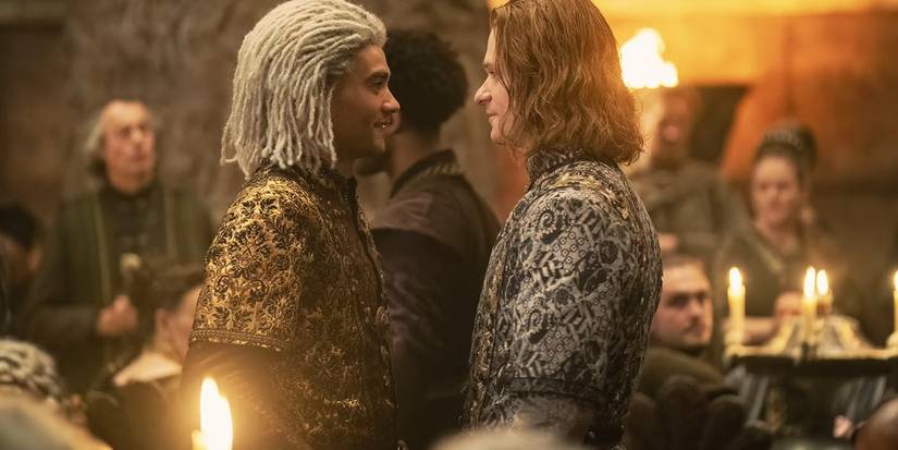 Laenor (Theo Nate) and Ser Joffrey Lonmouth (Solly McLeod) face to face and smiling in House of the Dragon.