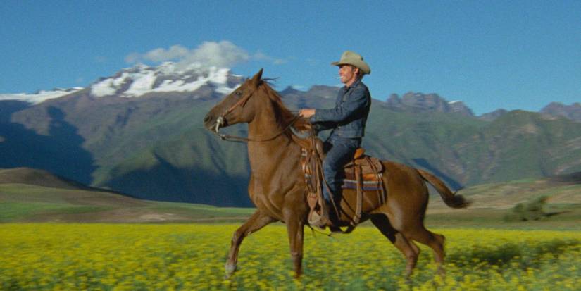 Dennis Hopper riding a horse through an open field in The Last Movie
