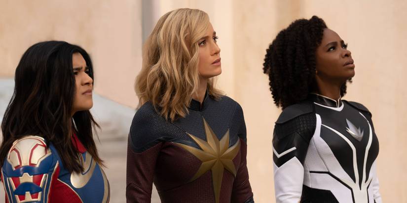 Kamala (Iman Vellani), Carol (Brie Larson), and Monica (Teyonah Parris) look up in The Marvels.