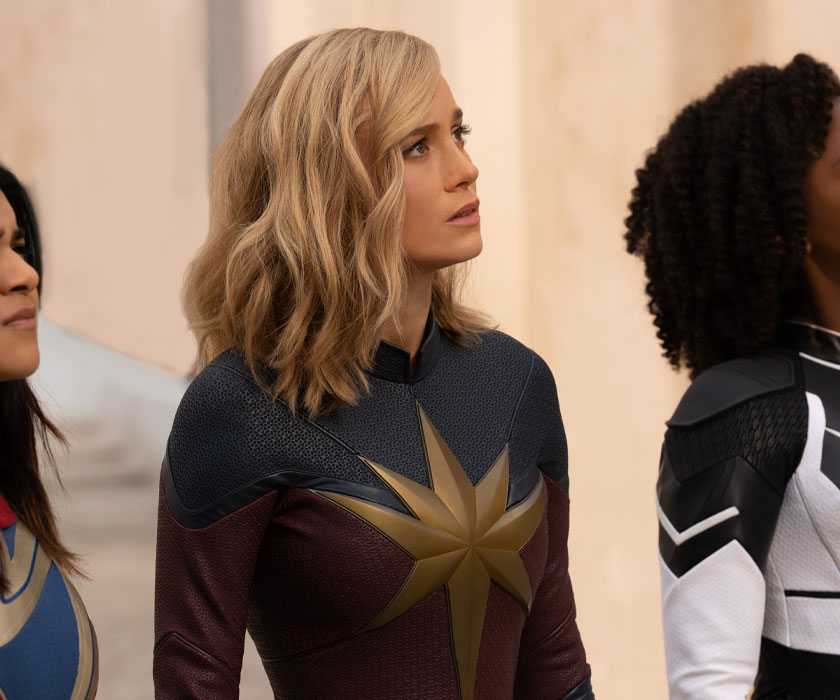 Kamala (Iman Vellani), Carol (Brie Larson), and Monica (Teyonah Parris) look up in The Marvels.