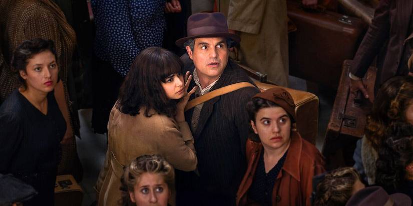 Mark Ruffalo as Daniel embracing Aria Mia Loberti as Marie-Laure in a crowd of people in All the Light We Cannot See