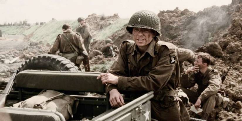 Damian Lewis as Richard Winters leaning on a jeep in Band of Brothers.