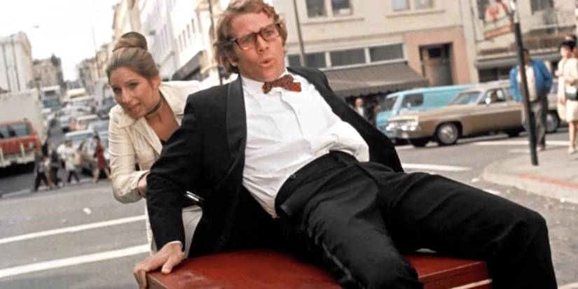 Ryan O'Neal on a piano while Barbra Streisand pushes him in What's Up, Doc?