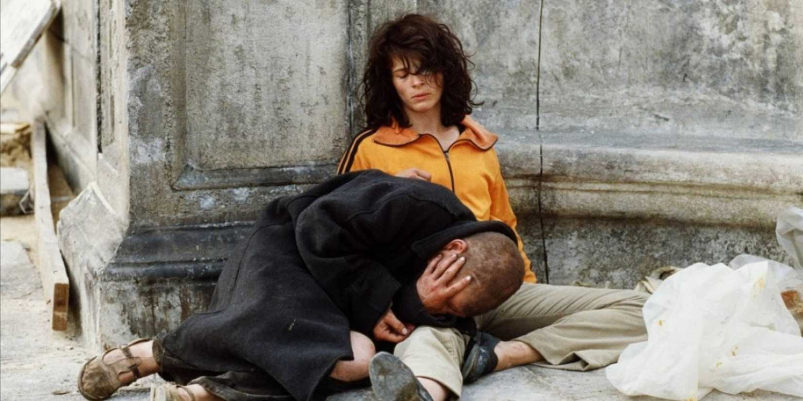 Denis Lavant lying on Juliette Binoche's lap while she sits on the floor in The Lovers on the Bridge