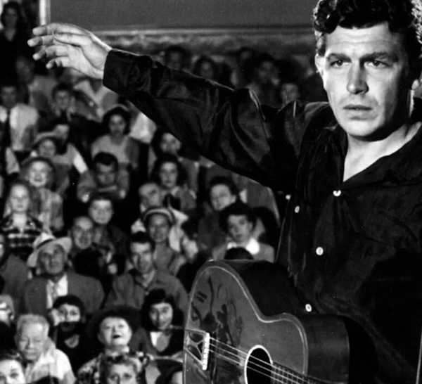 Andy Griffith performs with a guitar for a large crowd as Larry in A Face in the Crowd
