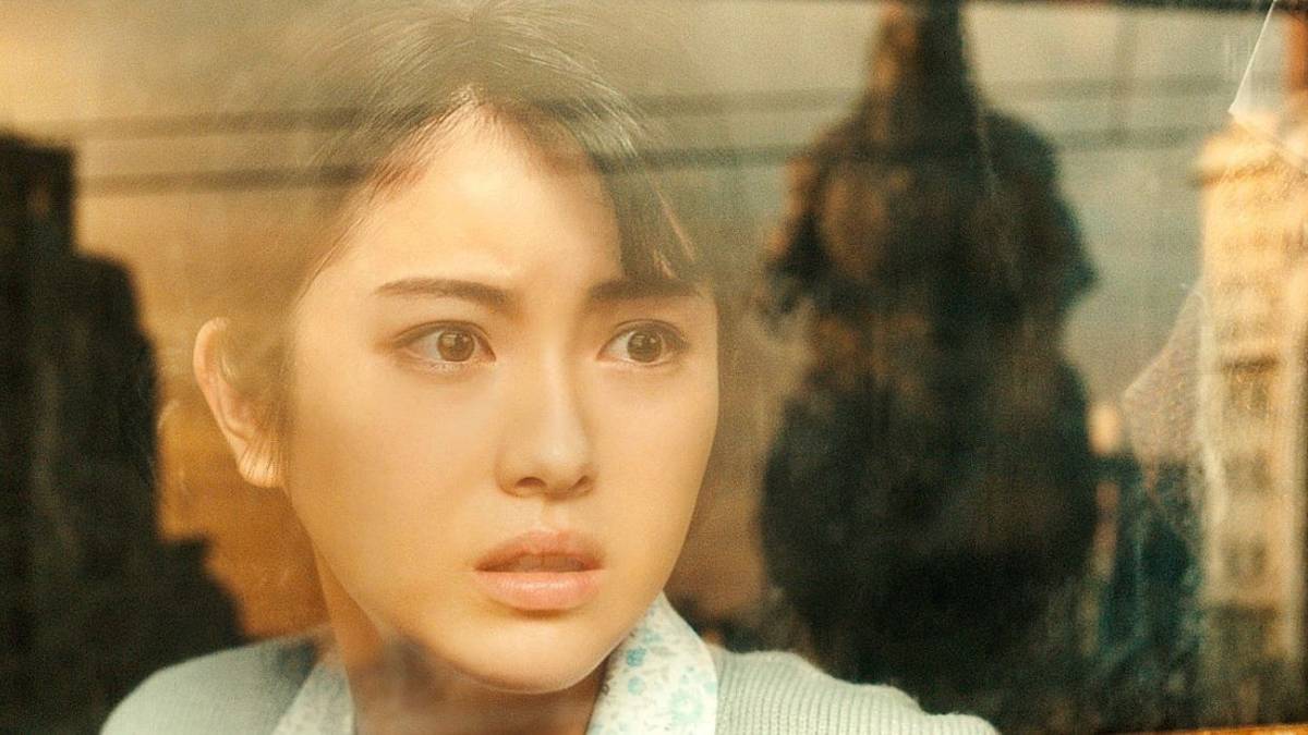 Minami Hamabe as Noriko Oishi staring out a window at Godzilla in Godzilla Minus One