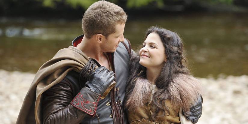 Prince Charming has his arm around Snow White as they look and smile at each other in Once Upon a Time. 