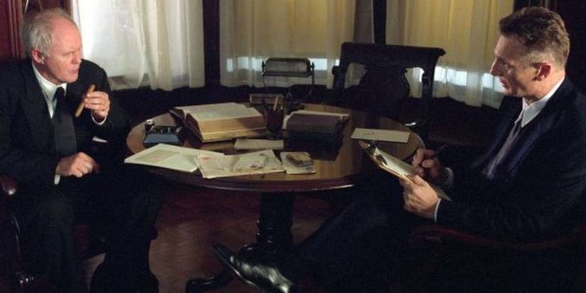 John Lithgow and Liam Neeson as Alfred Seguine Kinsey and Alfred Kinsey talking from across a table in the film Kinsey